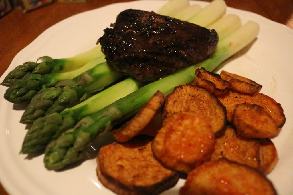 Jugoso bistec con una rica salsa de vino tinto, batata crujiente y espárragos verdes frescos