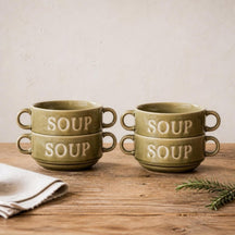 Vier groene Soup soepkommen gestapeld in twee stapels op een eiken tafel