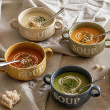 Vier Soup soepkommen in vier kleuren met verschillende soepen, van bovenaf