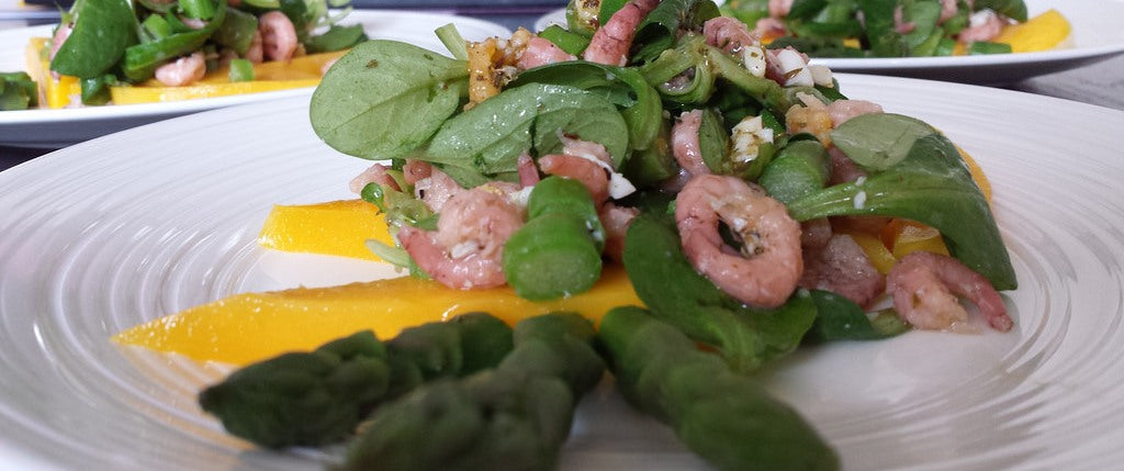 Una fresca ensalada de primavera con espárragos verdes, gambas y mango