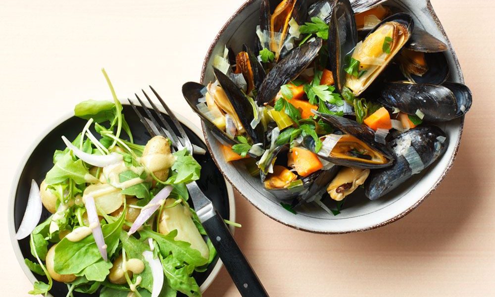 Mejillones frescos con verduras y una fresca ensalada de patatas pequeñas con rúcula
