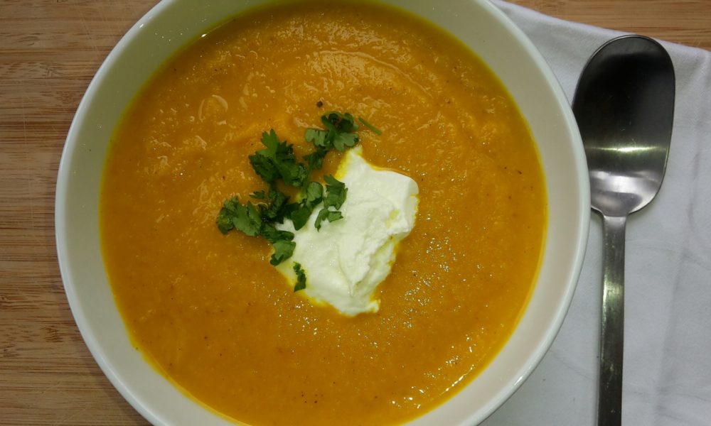 Una sopa de zanahoria cremosa y especiada con un toque de curry y cilantro fresco
